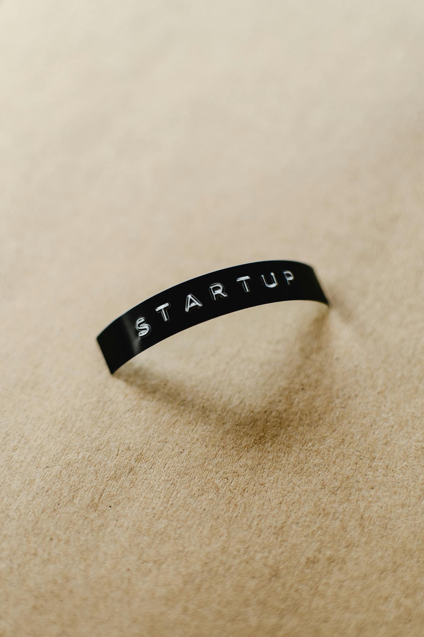 Close-up of a black label with 'STARTUP' text on a beige background, perfect for conceptual business themes.