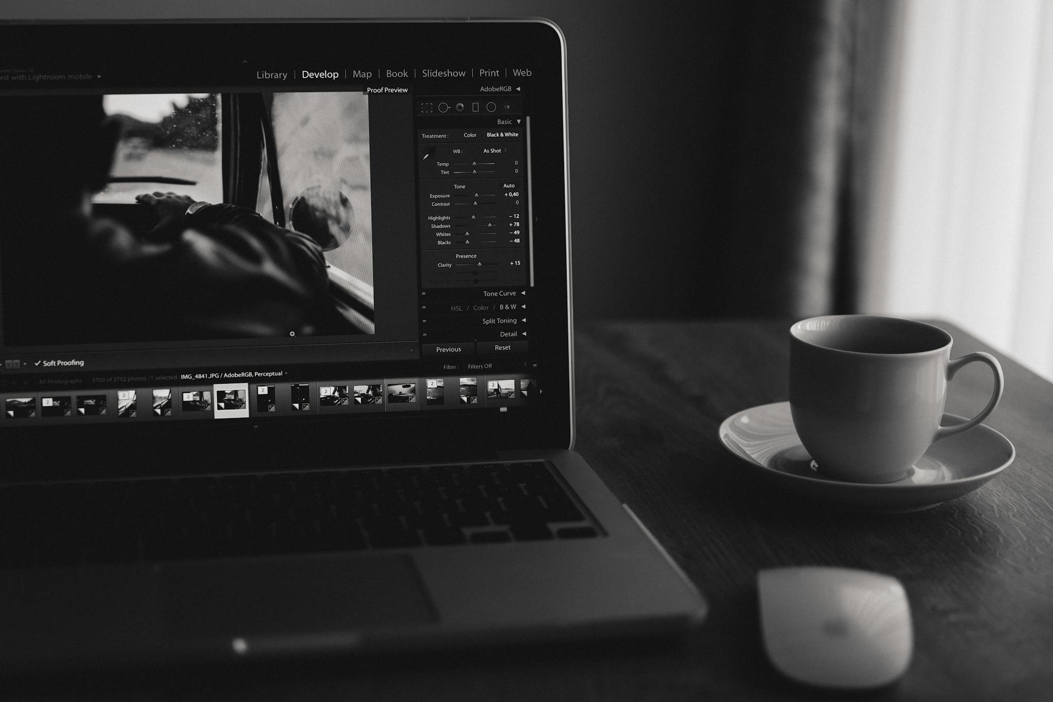 Minimalist black and white photo of a laptop with coffee. Ideal for home office themes.